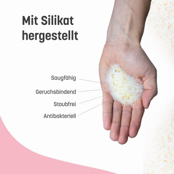 Hand hält weiße und gelbe Silikagranulate mit deutschem Text, der Eigenschaften beschreibt: saugfähig, geruchsbindend, staubfrei, antibakteriell.