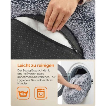 Hand, die den abnehmbaren, maschinenwaschbaren Bezug eines grauen Plüsch-Hundebetts aufzippt; sichtbarer deutscher Text 'Leicht zu reinigen'.