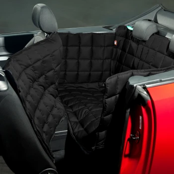Schwarze, gesteppte Autositzabdeckung für Haustiere in einem Cabrio, die die Rückbank schützt, mit Blick auf das Armaturenbrett und das Lenkrad.