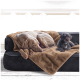 Ein großer grauer Hund und ein kleiner schwarzer Pudel ruhen sich auf einer dunklen Couch aus, die mit einer braunen Decke bedeckt ist, in einer gemütlichen Innenumgebung.