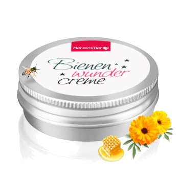 Silberne Dose der HerzensTier Bienen Wunder Creme mit Biene, Wabe und gelben Blumen auf weißem Hintergrund.