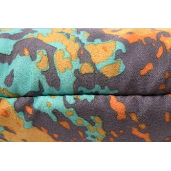 Nahaufnahme eines Haustierbettes mit einem bunten, abstrakten Muster in Türkis-, Orange- und Grautönen.
