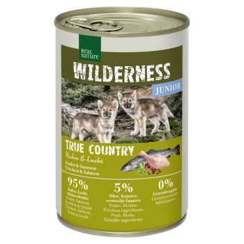 Dosen-Hundefutter mit der Aufschrift 'Wilderness Junior', das zwei Wolfwelpen auf der Vorderseite zeigt, mit Zutaten: 95% Huhn und Lachs, 5% Früchte und Kräuter.