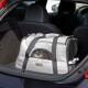 Eine graue Tiertrage mit Netzfenstern im Kofferraum eines Autos, mit einem kleinen Hund, der herausblickt, und einem "lionto"-Etikett.