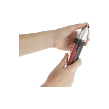 Eine Person hält einen Haustier-Nagelknipser mit einem silbernen Kopf und einem rot-schwarzen Griff, bereit, die Nägel eines Haustieres zu schneiden.