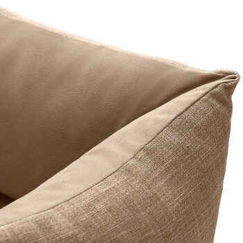 Nahaufnahme einer beigen Haustierbett-Ecke, die weiche Stofftexturen und ein plüschiges Kissen-Design zeigt.