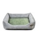 Graues Haustierbett mit einem weichen grünen Kissen, mit erhöhten Seiten für Komfort und einem kleinen Lederschild an der Seite.