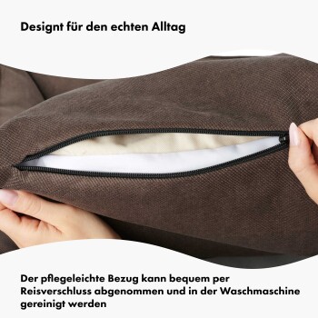 Nahaufnahme eines braunen Haustierbettbezugs mit Reißverschluss, der Hände zeigt, die ihn aufziehen. Text auf Deutsch hebt die einfache Entfernung und Maschinenwaschbarkeit hervor.