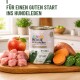 Dose mit Aufschrift JUNIOR MENUE MIT KANINCHEN mit rohem Kaninchen, Apfel und Süßkartoffel; Text 'FÜR EINEN GUTEN START INS HUNDELEBEN'.