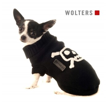 Ein schwarz-weißer Chihuahua in einem hochkragen schwarzen Pullover mit einem weißen Totenkopfdesign. "WOLTERS" befindet sich in der oberen rechten Ecke.