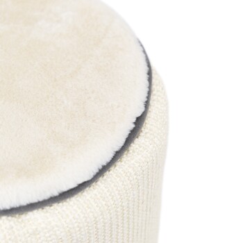 Eine Nahaufnahme eines runden Haustierbettes mit einer weichen, plüschigen cremefarbenen Oberseite und einem strukturierten, beige gewobenen Boden.