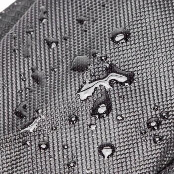 Nahaufnahme einer strukturierten schwarzen Stoffoberfläche mit Wassertropfen, die ihre wasserabweisenden Eigenschaften zeigt.