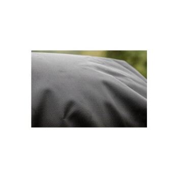 Nahaufnahme eines strukturierten schwarzen Stoffes, möglicherweise eines Haustierbettes oder -bezugs, mit subtilen Falten und einem verschwommenen grünen Hintergrund.