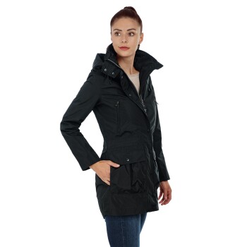 Eine Frau trägt eine stilvolle schwarze wasserdichte Jacke mit Kapuze, die mit Reißverschluss und geknöpften Taschen ausgestattet ist, und steht selbstbewusst.