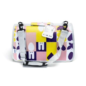 Bunte Haustiertragetasche mit geometrischen Mustern in Pink, Gelb und Lila, mit einem grauen Riemen und einem Etikett mit Produktdetails.