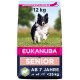 Eukanuba Senior Hundefutterbeutel, 12 kg, mit einem laufenden schwarz-weißen Hund auf einem Grasfeld; der Text enthält 'AB 7 JAHRE' und 'WIEDERVERSCHLIESSBAR'.