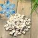 Haufen hellbeiger gefriergetrockneter Tierfutterwürfel auf Holzbrett, blaues Schneeflocken-Symbol mit der Aufschrift 'Gefrier-getrocknet'.