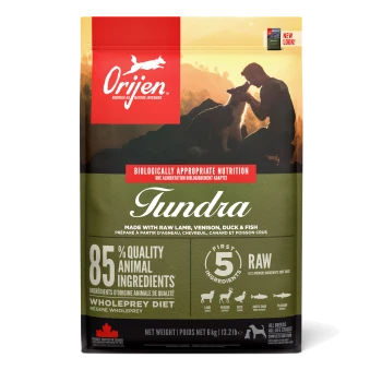 Orijen Tundra Haustierfutterbeutel mit einer malerischen Kulisse mit einer Person und einem Hund. Der Text hebt 85 % hochwertige tierische Zutaten und eine Rohkostdiät hervor.