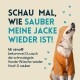 Ein glücklicher Hund in einem orangefarbenen Regenmantel mit reflektierenden Streifen. Text: "Schau, wie sauber meine Jacke ist! Mit nimo® ist sogar schmutzige Hundewäsche frisch!"