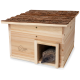 Ein Holz-Igelhaus mit einem mit Rinde bedeckten Dach, das einen kleinen Eingang und einen Igel, der herausblickt, zeigt. Das Haus ist mit "wildlife home" gebrandet.