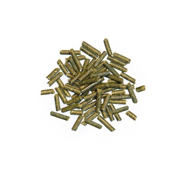 Grüne Haustierfutterpellets, die auf einem weißen Hintergrund verstreut sind und kleinen Stöcken oder Zweigen ähneln.