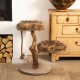 Katzenbaum aus natürlichem Holz mit zwei plüschigen, mit Fell bezogenen Plattformen und einem Sisal-Seil zum Kratzen, in einem gemütlichen Raum aufgestellt.