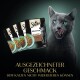 Eine graue Katze leckt sich die Lippen neben vier Sheba Katzenfutterbeuteln mit der Aufschrift "Selection in Sauce mit Ente."