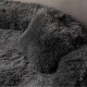 Weiches, plüschiges graues Haustierbett mit passendem Kissen, mit einer strukturierten, fusseligen Oberfläche für Komfort.