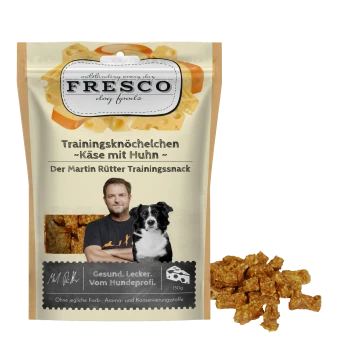 FRESCO-Hundesnack-Tasche: "Trainingsknöchelchen - Käse mit Huhn", "Der Martin Rütter Trainingssnack", 150 g, Foto von Mann und Hund, Haufen ausgestreuter Leckerlis.