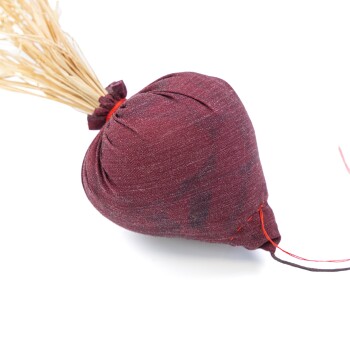 Ein kastanienbraunes Stoffspielzeug für Katzen in Herzform mit herausragendem Stroh, entworfen für das Spielen von Haustieren.