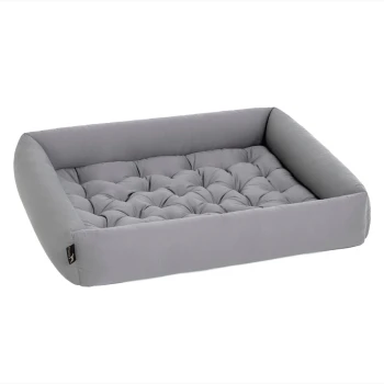 Graues Haustierbett mit einem gepolsterten Design und erhöhten Kanten, das Komfort und Unterstützung für Haustiere bietet.