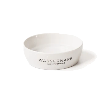 Weißer Keramik-Haustier-Wasserbehälter mit dem Text "WASSERNAPF stay hydrated" auf der Seite, gefüllt mit klarem Wasser.