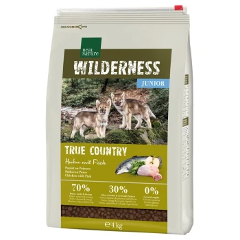 A bag of Real Nature Wilderness Junior pet food featuring two wolf pups on the front, labeled "True Country" with chicken and fish ingredients.