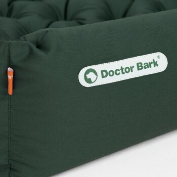 Grünes Haustierbett mit gepolstertem Design, mit einem weißen "Doctor Bark"-Logo an der Seite.