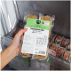 Hand hält eine Packung gefrorenes Hundefutter BARFER'S Komplett‑Mix Huhn & Lachs (400 g) in einem Gefrierschrank.