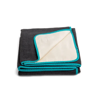 Eine gefaltete Haustierdecke mit einer dunkelgrauen Außenseite und einem weichen cremefarbenen Innenfutter, umrandet mit einem türkisfarbenen gepunkteten Rand.