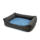 Graues Haustierbett mit einem weichen blauen Kissen, mit erhöhten Seiten für Komfort und einem kleinen Lederetikett an der Seite.