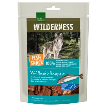 Eine "WILDERNESS" Haustiersnackverpackung mit einem Wolf im Wald, beschriftet mit "FISCHSNACK 100% ALASKA WILDLOCHS" und mehrsprachigem Text über Lachs.