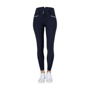 Navyblaue Reitleggings mit hohem Bund, mit zwei Fronttaschen und weißen sowie roten Streifen, kombiniert mit weißen Turnschuhen.
