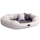 Ein gemütliches, ovales Haustierbett aus hellgrauem Stoff mit einem dunkler grauen Innenraum, ausgestattet mit zwei kleinen dekorativen Kissen.