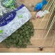 Verschüttete grüne Graswürfel für Haustiere auf einem Holztisch; eine Plastiktüte mit blauem Oval, auf dem '100%' und 'Premium' steht; zwei Spielzeugmäuse.