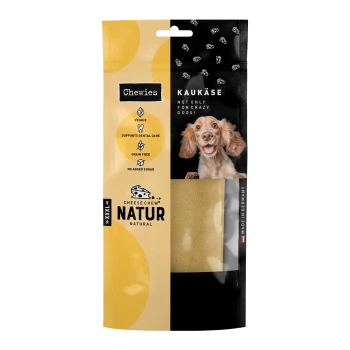 Verpackung des Käse-Kau-Natur-Hundeleckerlis mit einem lächelnden Hund, mit Text, der es als pflanzlich, getreidefrei und zahnmedizinisch unterstützend hervorhebt.