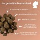 Haustierfutterpellets auf einem sanften Hintergrund mit "Hergestellt in Deutschland," "kalt gepresst," "natürliche Zutaten," und "Insektenprotein."
