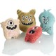Vier bunte plüschige Monster-Spielzeuge für Haustiere, mit verspielten Designs mit Augen und Zähnen, auf einer reflektierenden Oberfläche.