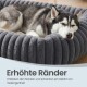 Schlafender Husky in einem weichen, grauen runden Donut-Bett mit erhöhten, gerippten Rändern; sichtbarer Text: 'Erhöhte Ränder' und deutscher Untertext.