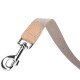 Eine Nahaufnahme einer Hundeleine mit einem beigen Stoffriemen und einem silbernen Metallclip, mit einem hellbraunen Lederanhänger in der Nähe des Clips.