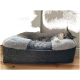 Eine graue getigerte Katze, die friedlich auf einem plüschigen, runden Haustierbett mit einem weichen grauen und dunkelgrauen Design schläft, mit dem Text 'Pet'.