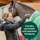 Eine Person in einer schwarzen Jacke reinigt ein Pferd in einer grünen Decke. Text: "Schnelle, porentiefe und natürliche Reinigung."