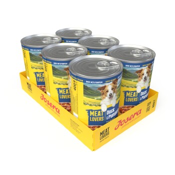 Tablett mit sechs Josera 'Meat Lovers' Hundefutterdosen — Sorte 'Duck with Pumpkin' — gelbe Etiketten mit fröhlichem Hund.