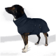 Ein stilvoller Hund trägt einen dunkelblauen Fleece-Mantel, steht stolz mit erhobenem Kopf und zeigt eine Tasche mit einem Etikett, auf dem "THE DOG GIG" steht.